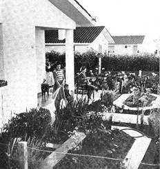Foto en blanco y negro de un grupo de personas alrededor de una casa

Descripción generada automáticamente