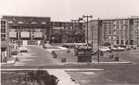 Foto en blanco y negro de una calle con edificios de fondo
Descripción generada automáticamente