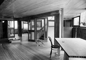 Foto en blanco y negro de un comedor con una mesa de madera
Descripción generada automáticamente con confianza media